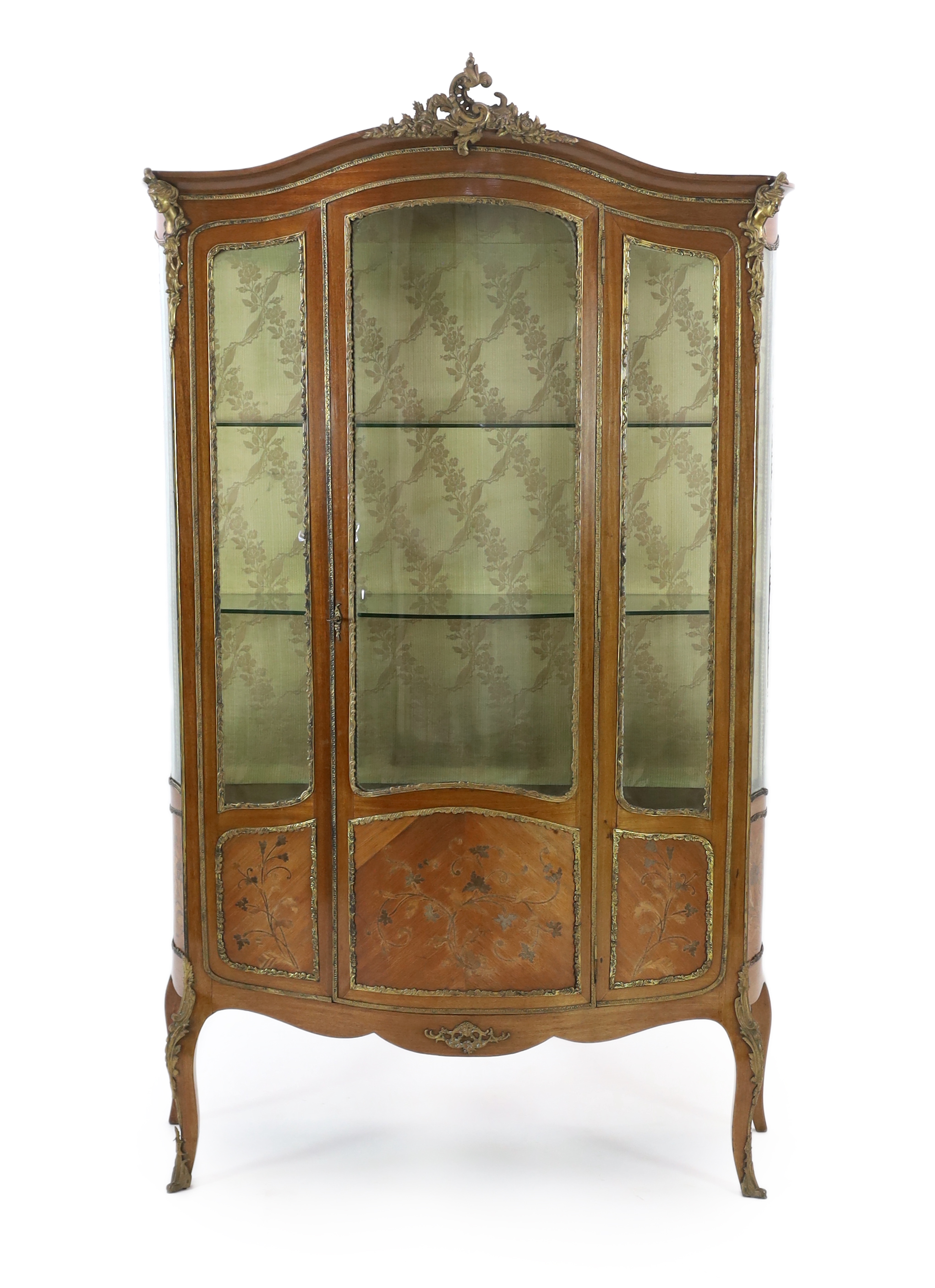 A French Louis XVI style marquetry inlaid vitrine, with ormolu mounts, single central door enclosing glass shelves, on cabriole legs, 120cm wide, 44cm deep, 210cm high